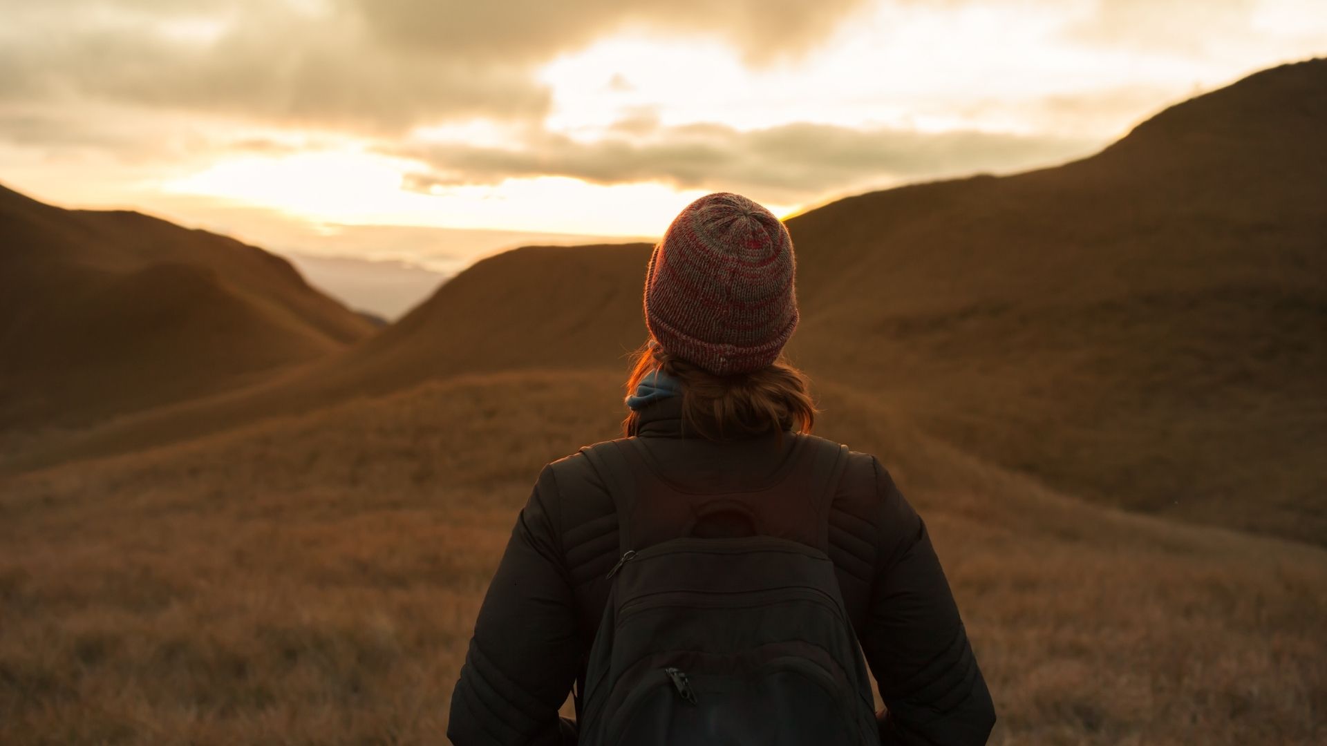 woman pensively looking out at mountains