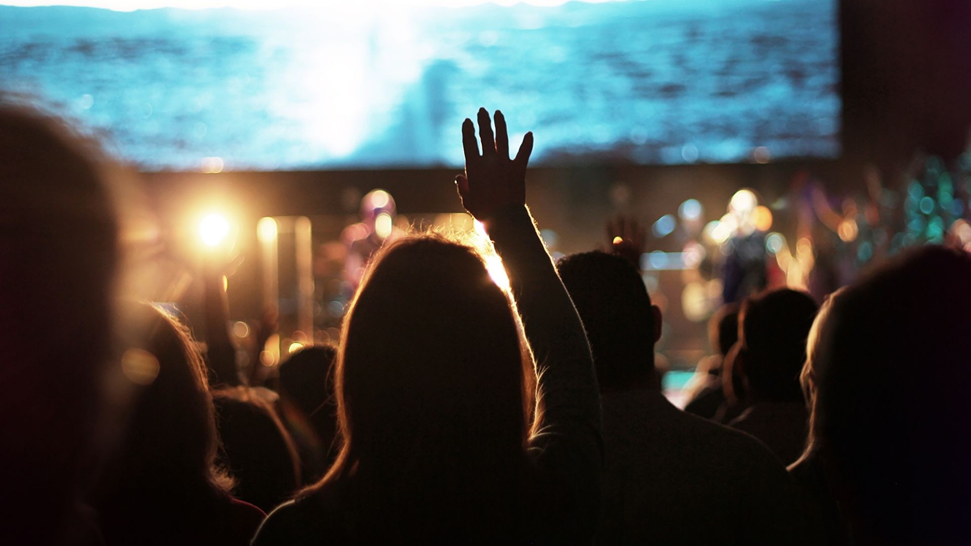 person lifting their hands in church